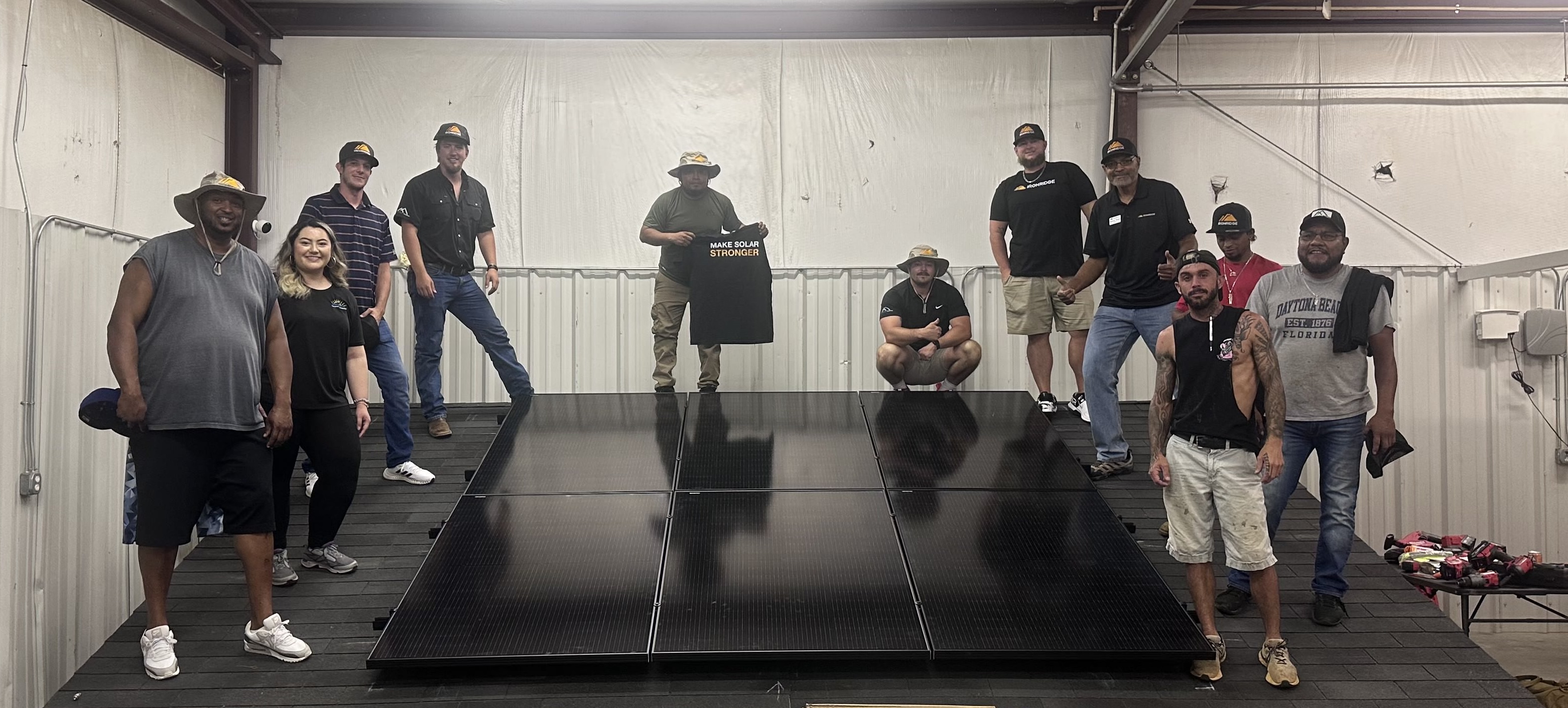 Olivia and trainees around a mock solar panel installation. 
